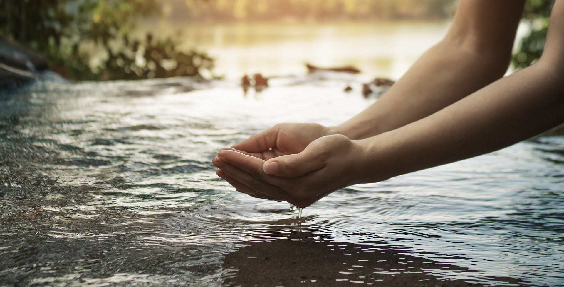 Image of a river with two outstretched hands cupping water